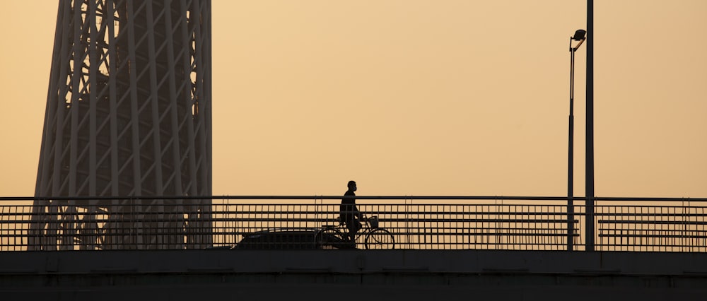 silhouette of man sitting on bench during sunset