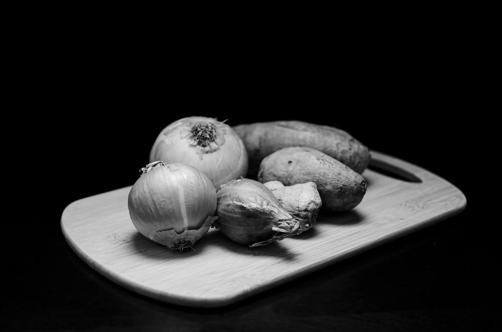 garlic on brown wooden chopping board