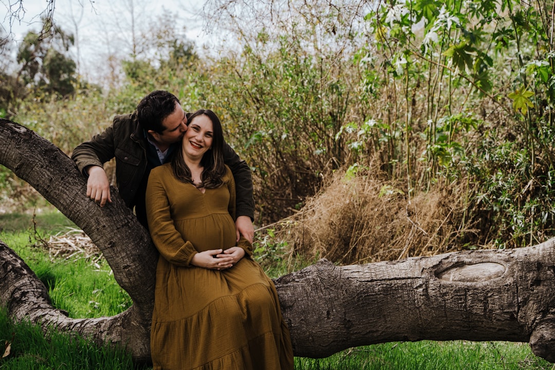 woman in brown dress sitting on tree log