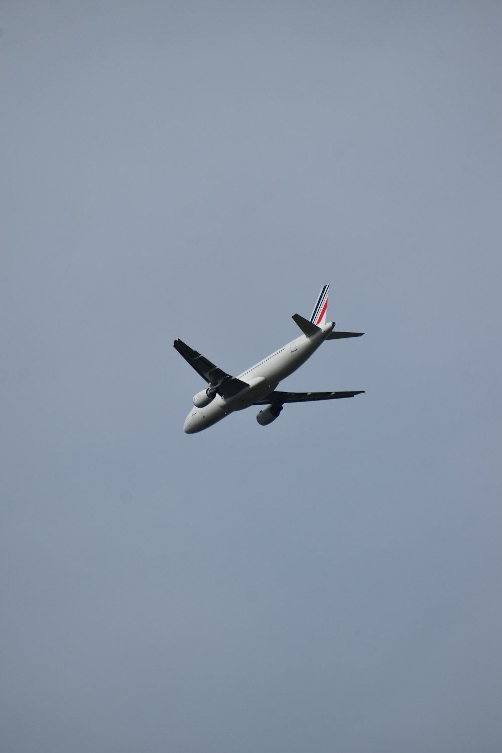 Weißes Flugzeug, das tagsüber am Himmel fliegt