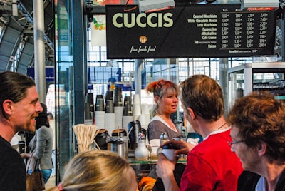 Wide shot of a high-traffic train station corner featuring multiple Sunday Coffee stations.