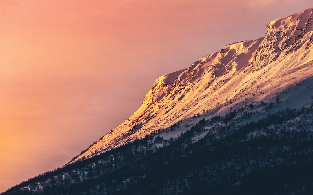 brown and white mountain under gray sky