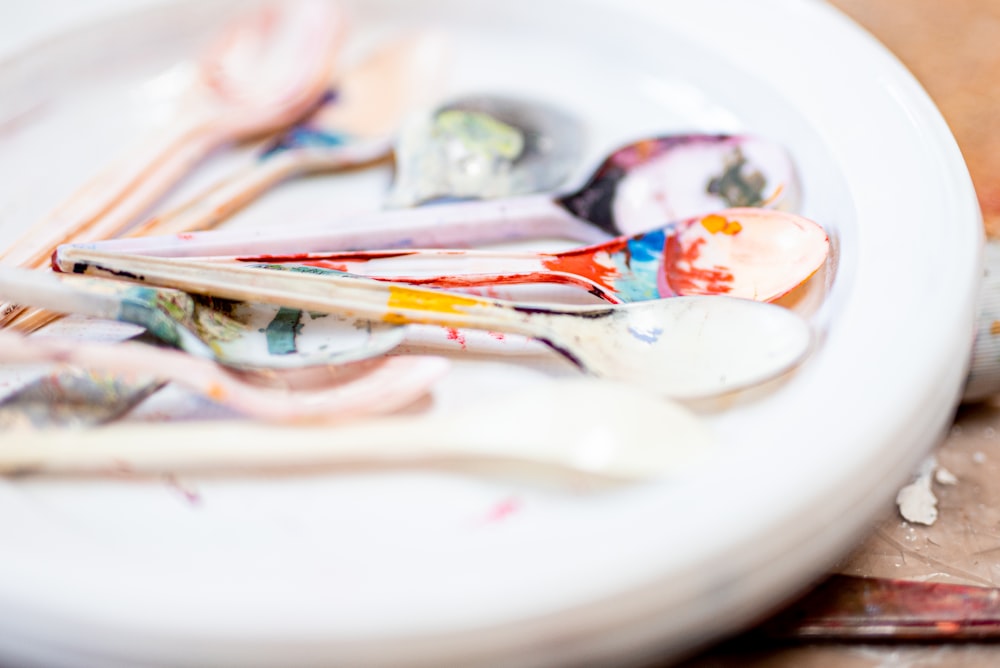 white ceramic plate with paint brushes