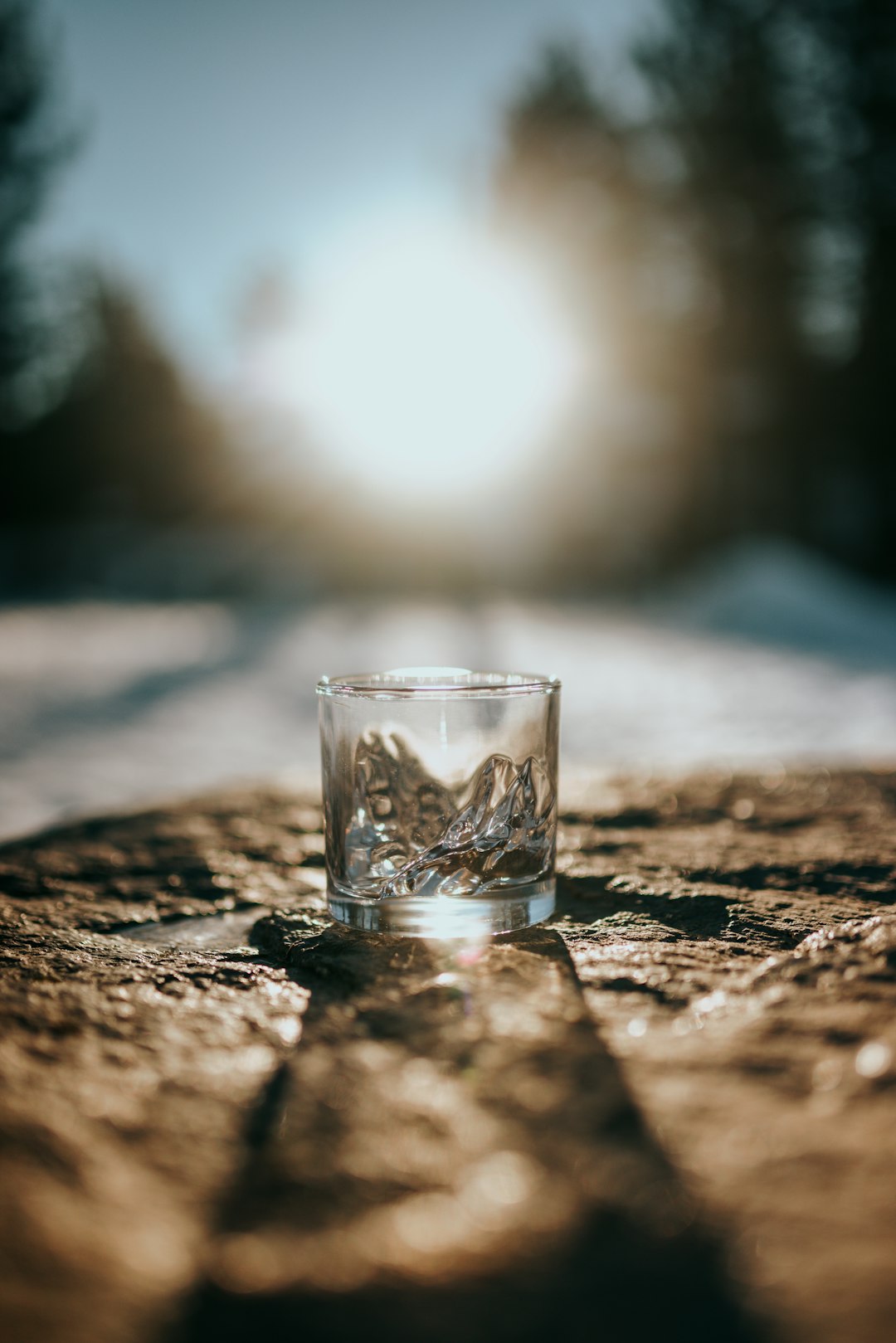 clear shot glass on brown and black marble table