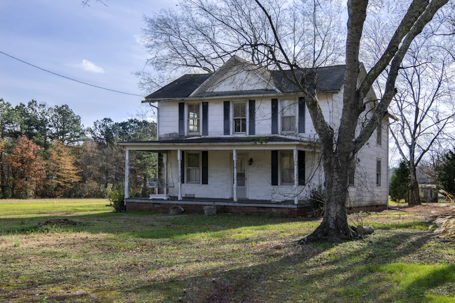 A white two-story farmhouse with a wide front porch