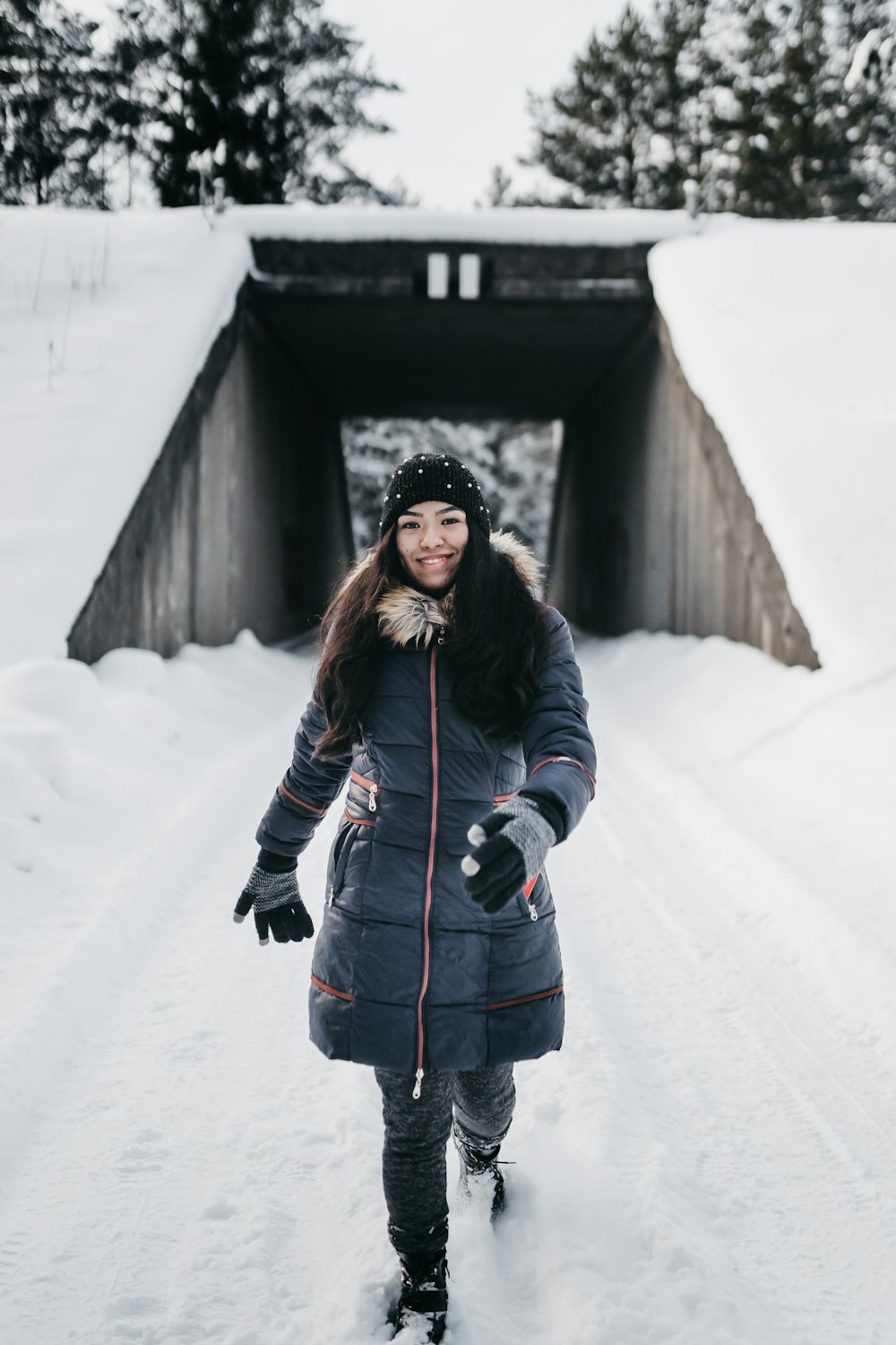 woman in black winter coat standing on snow covered ground