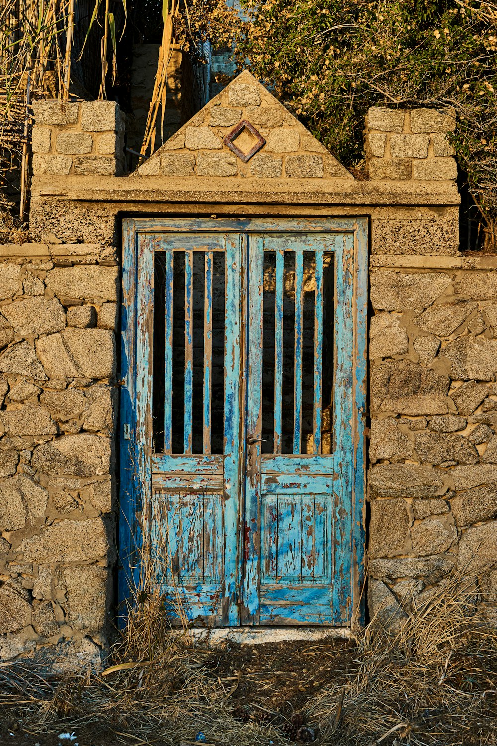 puerta de madera azul sobre pared de ladrillo marrón