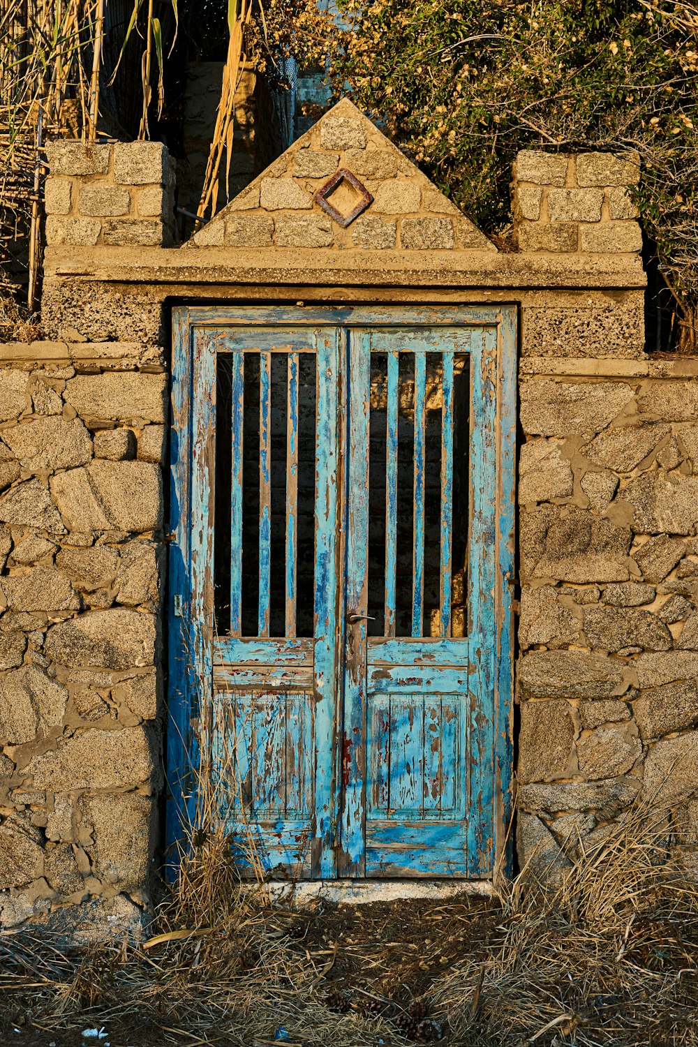Porte en bois bleu sur mur de briques brunes