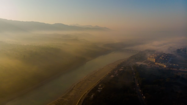 A serene view of the Yangtze River winding through Chongqing's misty mountains at dawn.