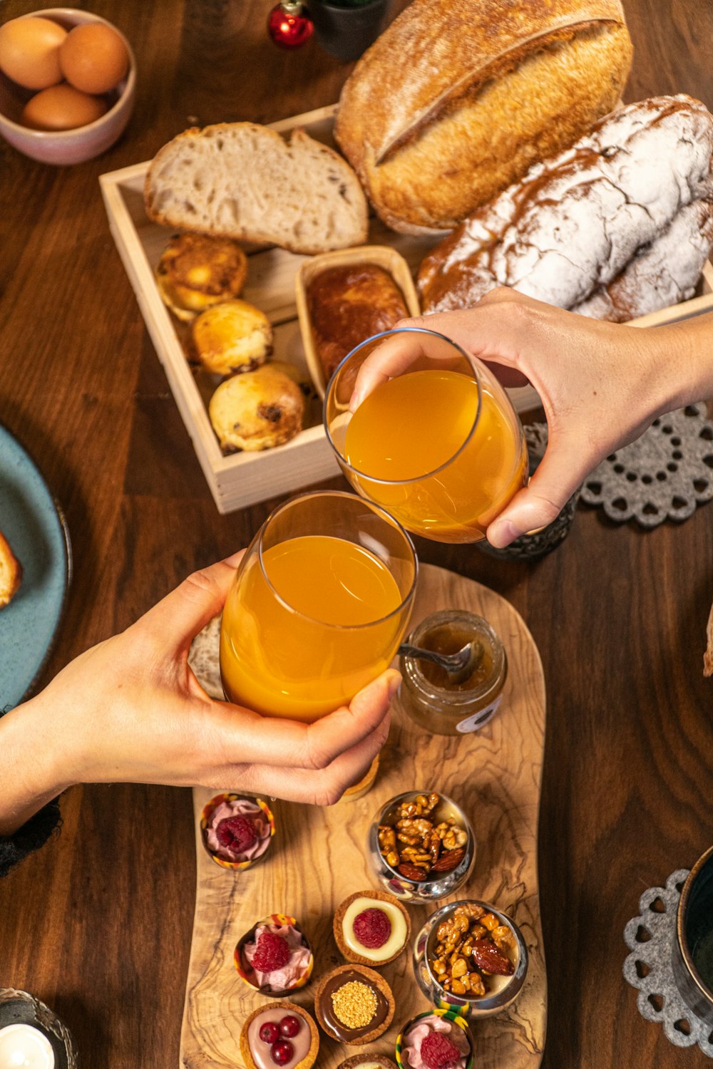 person holding clear drinking glass with orange liquid