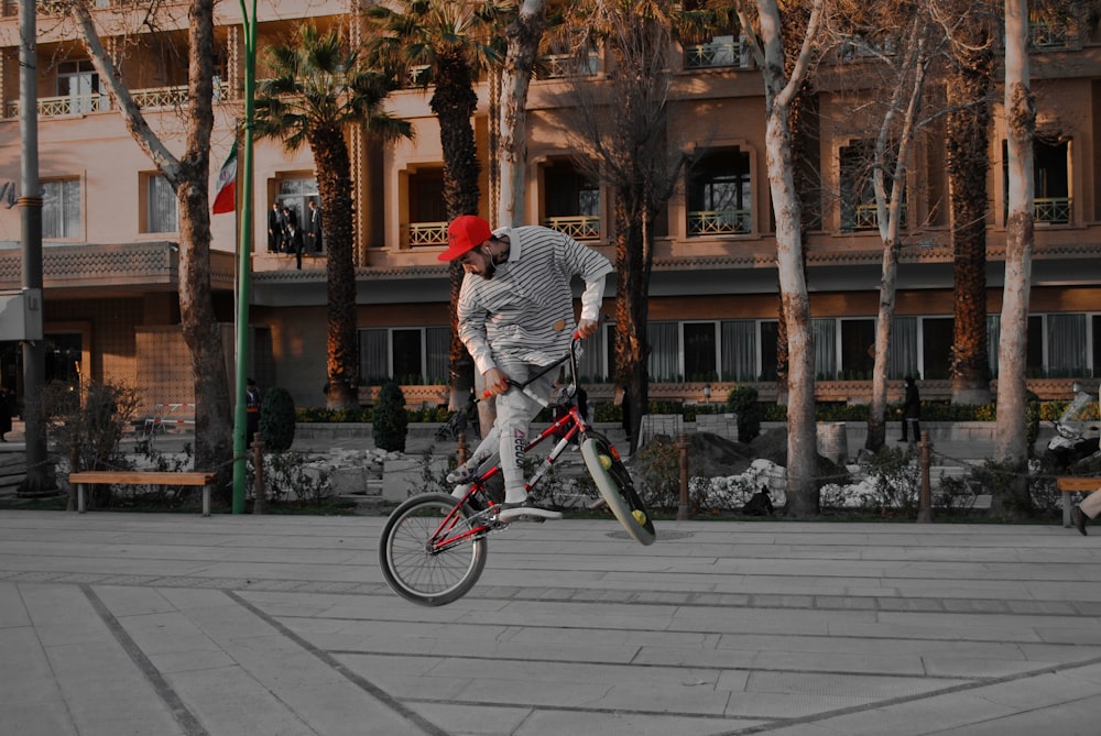 man in gray and black stripe long sleeve shirt riding on bicycle during daytime