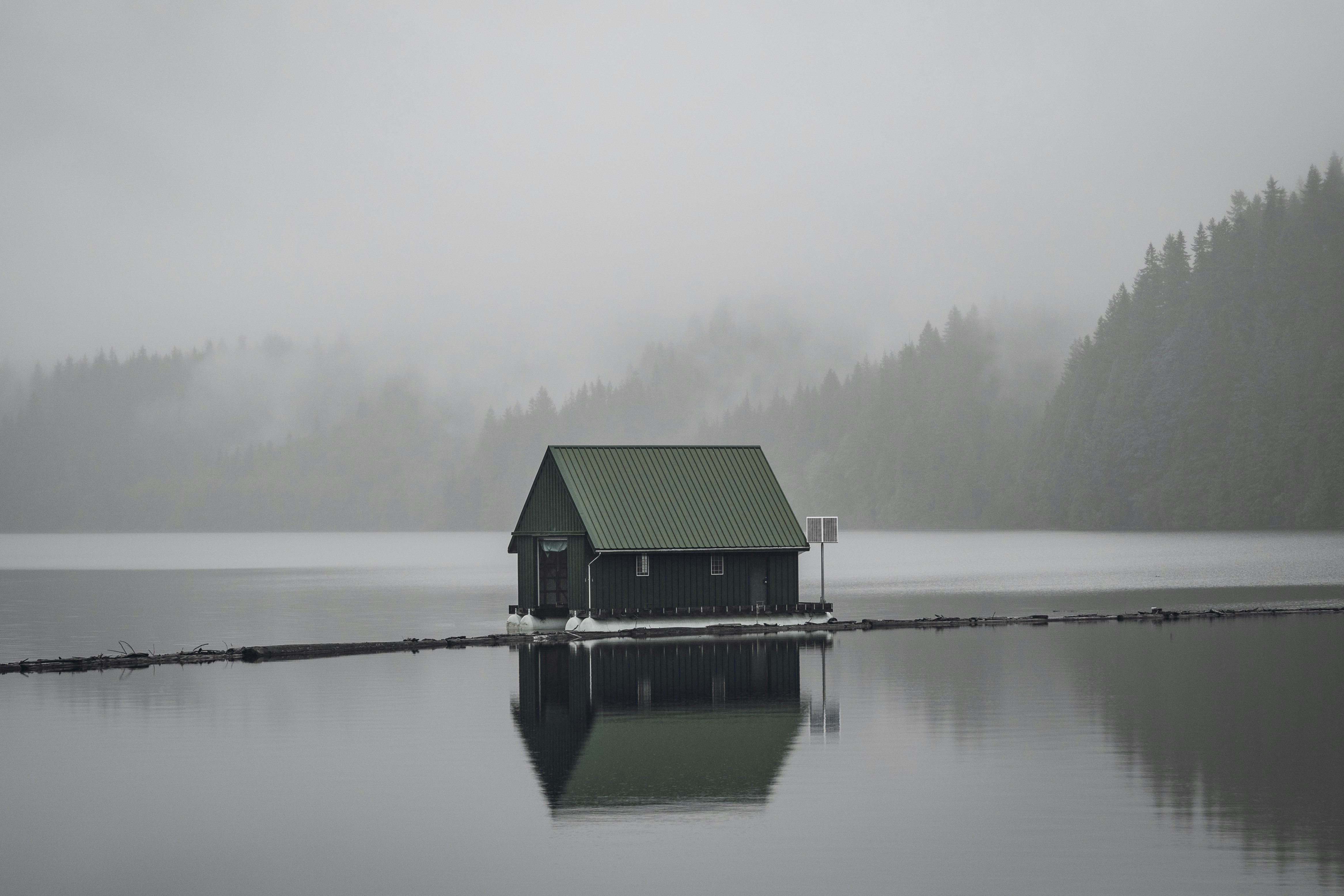 casa di legno grigia sullo specchio d'acqua