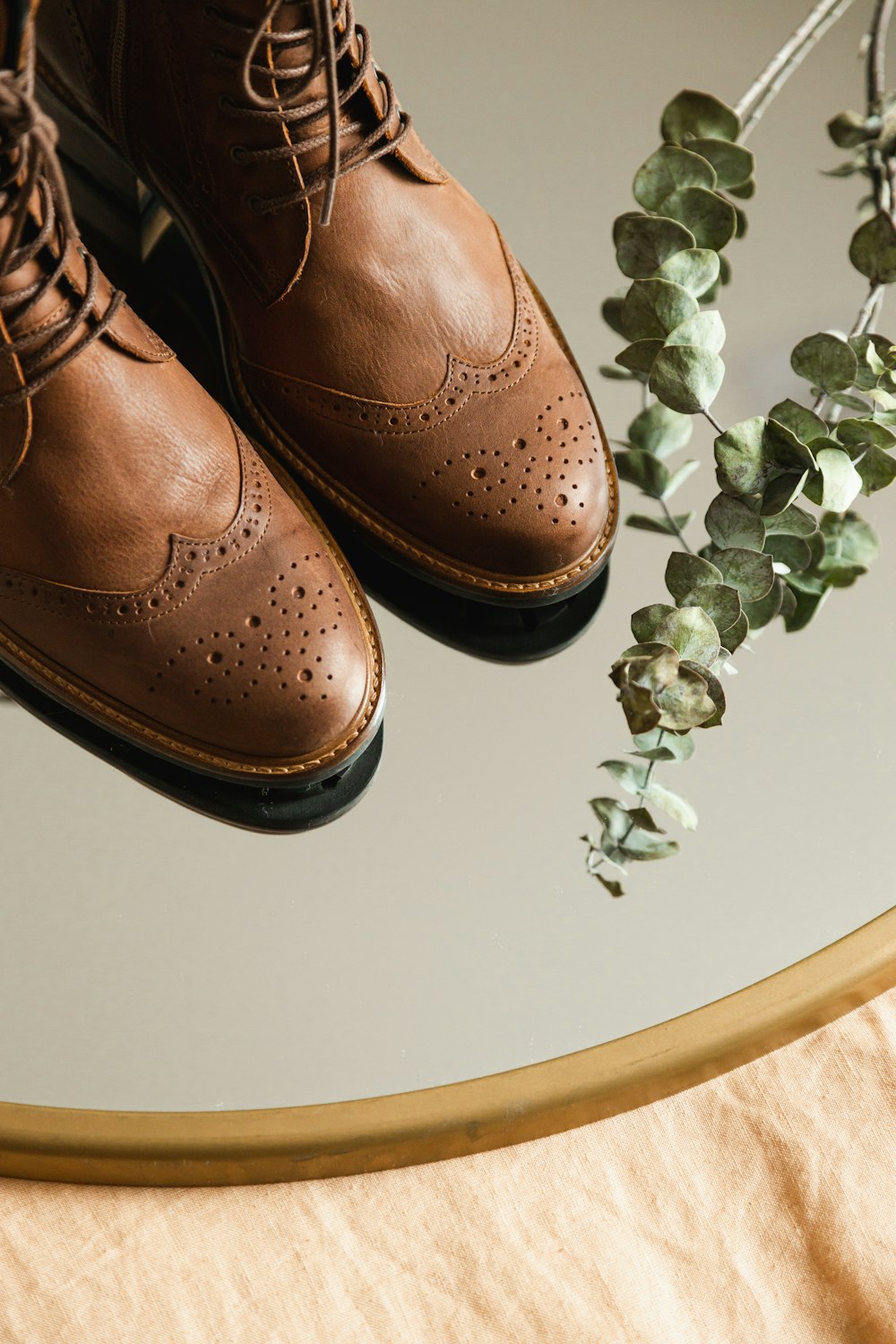 brown leather shoes on white table