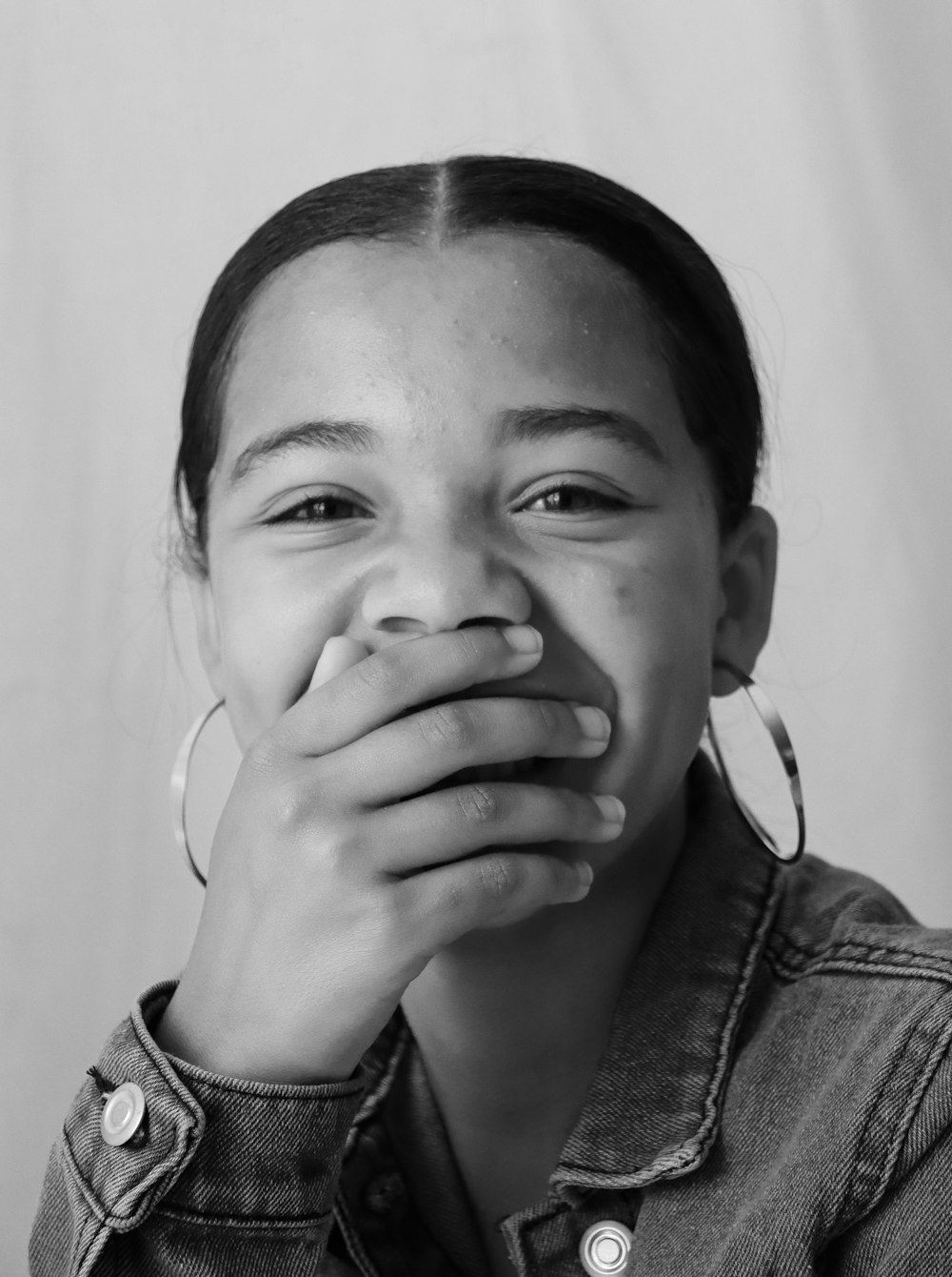 grayscale photo of woman covering her face with her hand