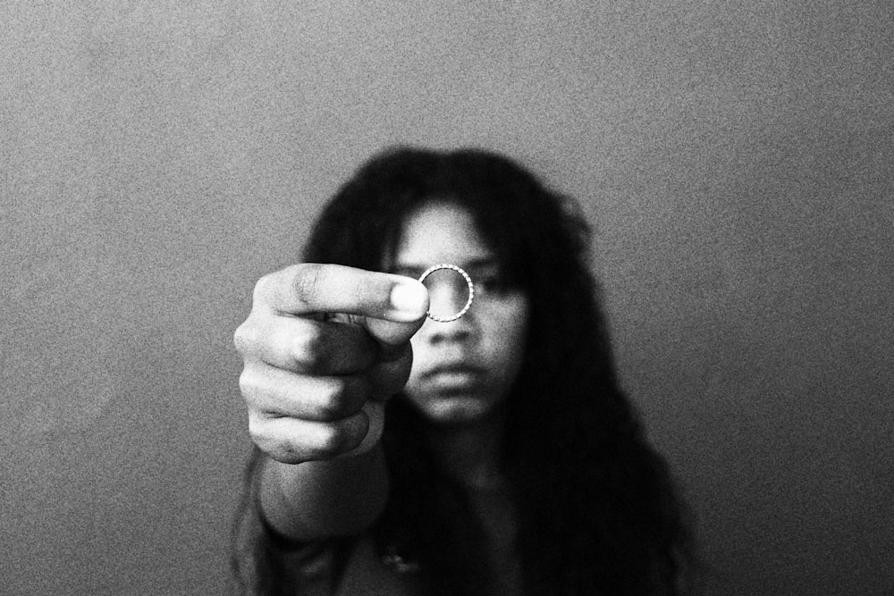 grayscale photo of woman holding heart shaped ornament