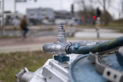 Close-up view of a safety valve on a stationary tank with a Tijuana skyline behind.