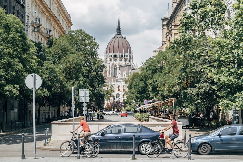 people walking on sidewalk near cars and building during daytime