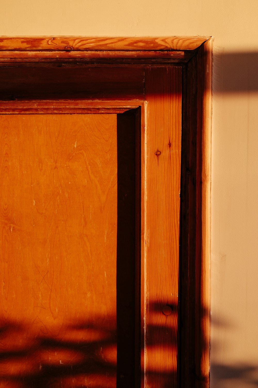 brown wooden frame on white wall