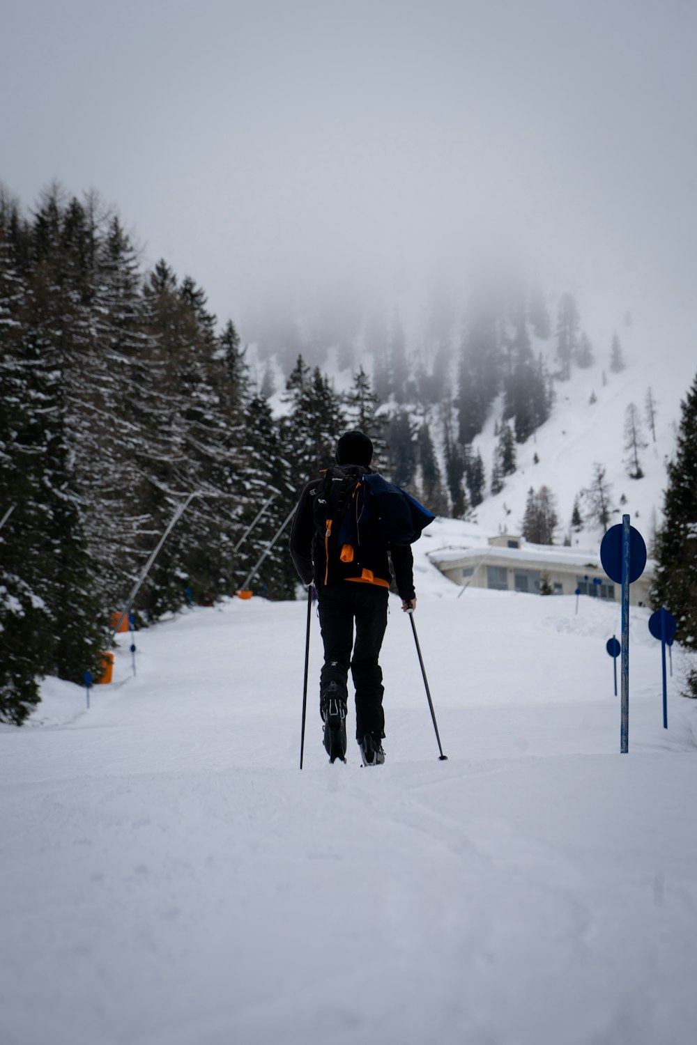 man in black jacket and red backpack standing on snow covered ground during daytime