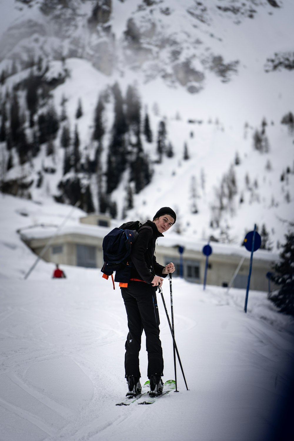 man in black jacket and black pants holding ski poles on snow covered ground during daytime