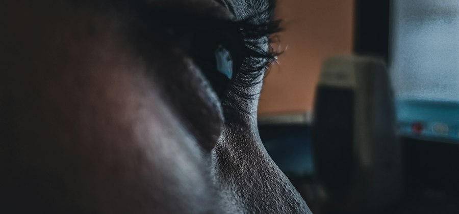 A person on a video call at a desk glancing away from the screen toward a nearby window