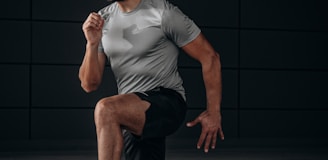 man in white crew neck t-shirt and black shorts sitting on floor