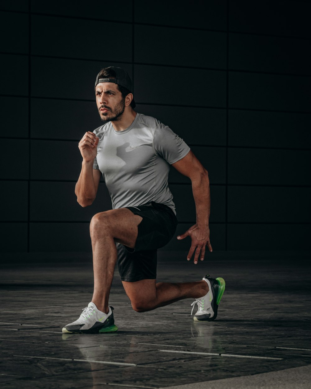 man in white crew neck t-shirt and black shorts sitting on floor