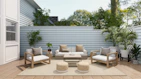 A cozy outdoor patio featuring comfortable seating with neutral cushions and surrounding greenery.