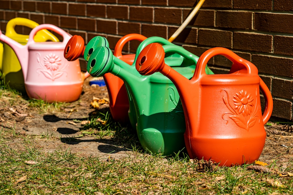 red green and blue plastic watering cans