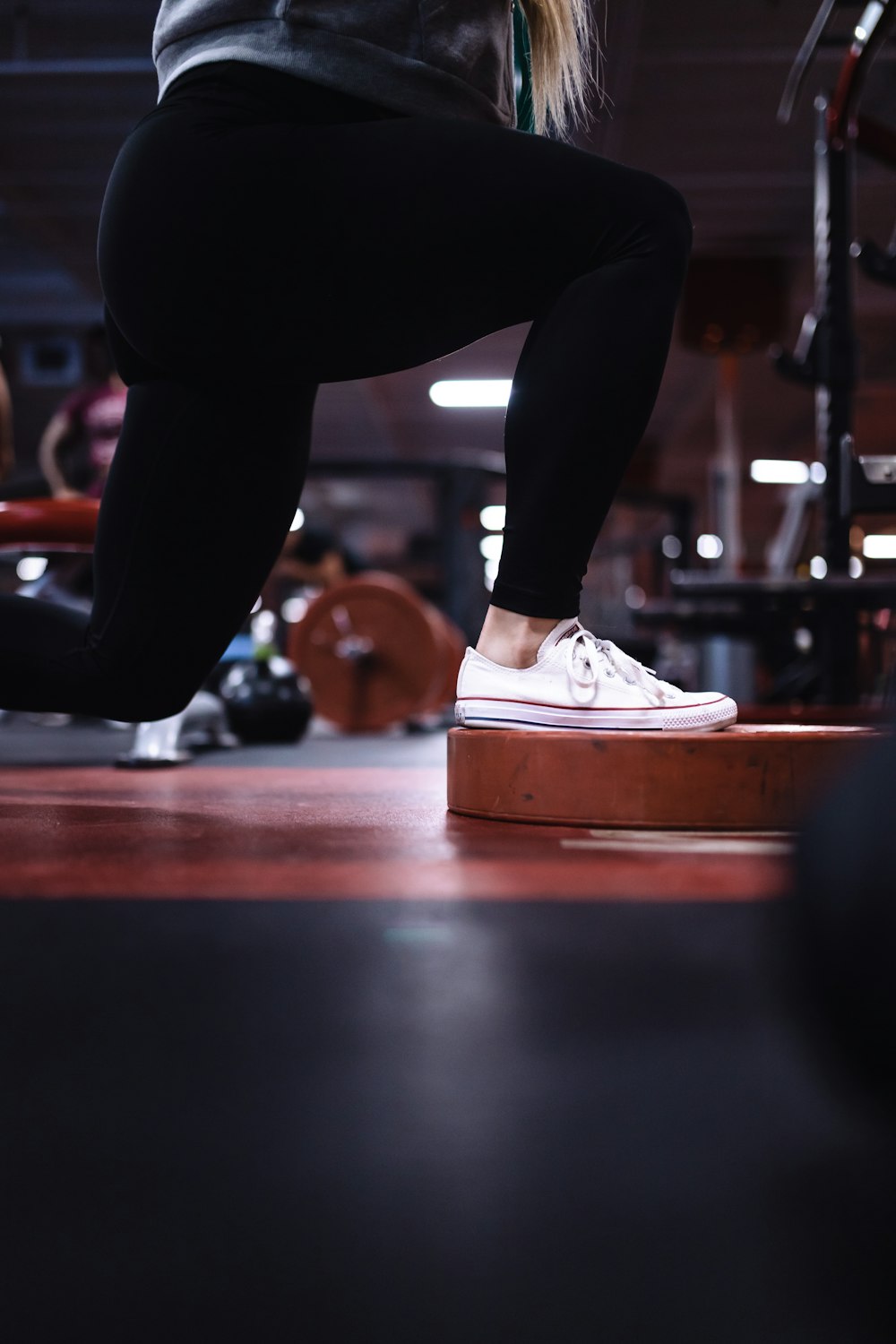 person in black pants and white and orange nike sneakers