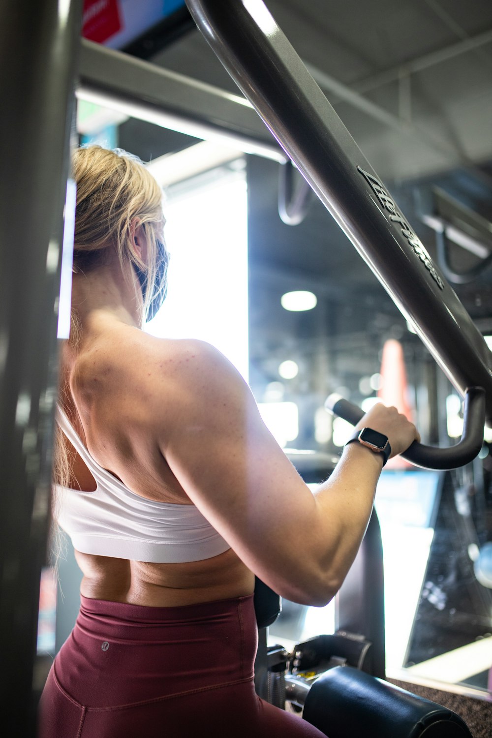 woman in white sports bra and white panty holding black smartphone