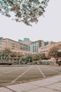 brown and white concrete building near green trees during daytime