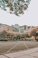 brown and white concrete building near green trees during daytime