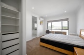 A neatly arranged, freshly assembled bedroom with modern furniture and clean floors.