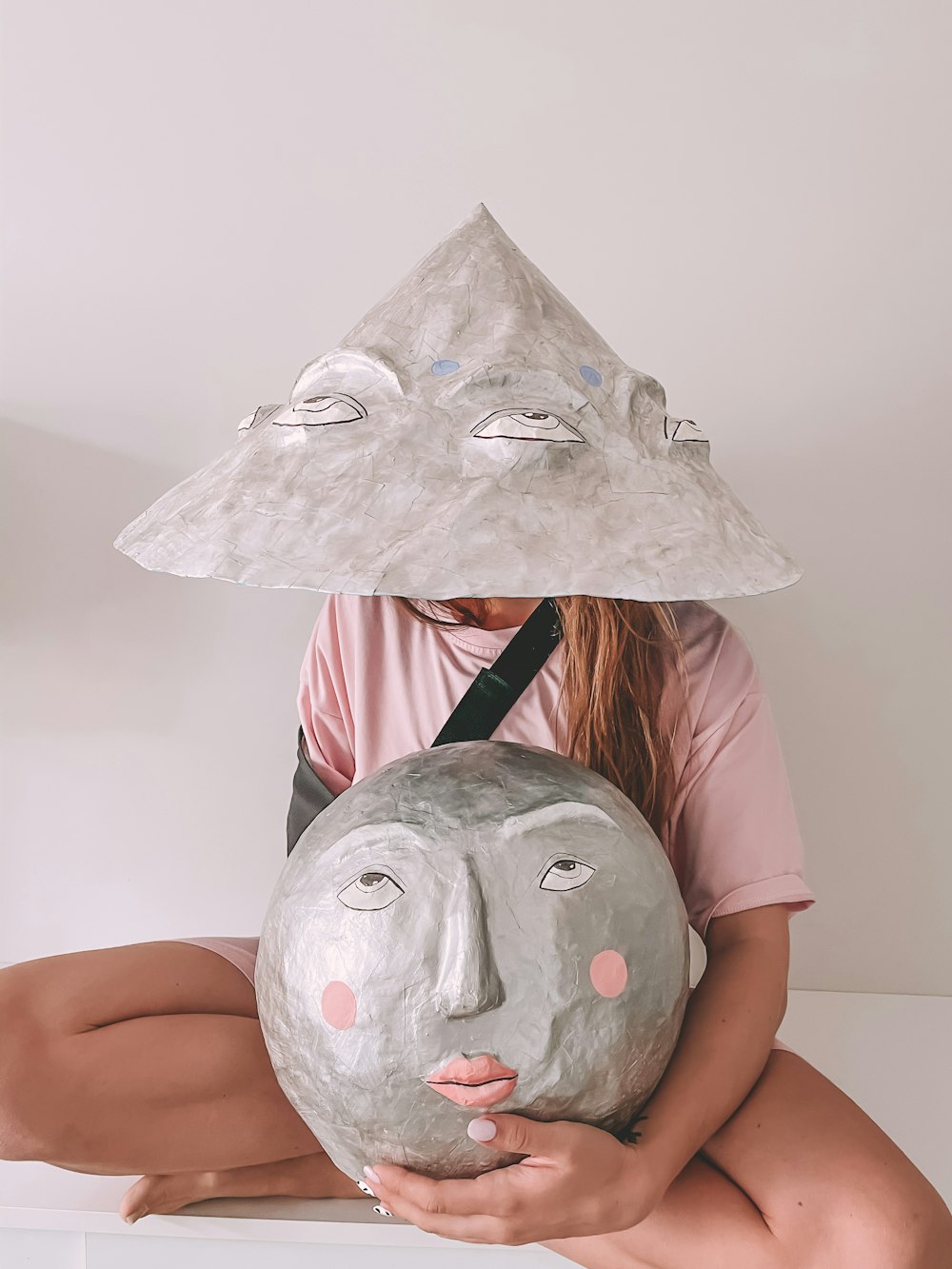 girl in pink t-shirt holding white and gray animal face mask