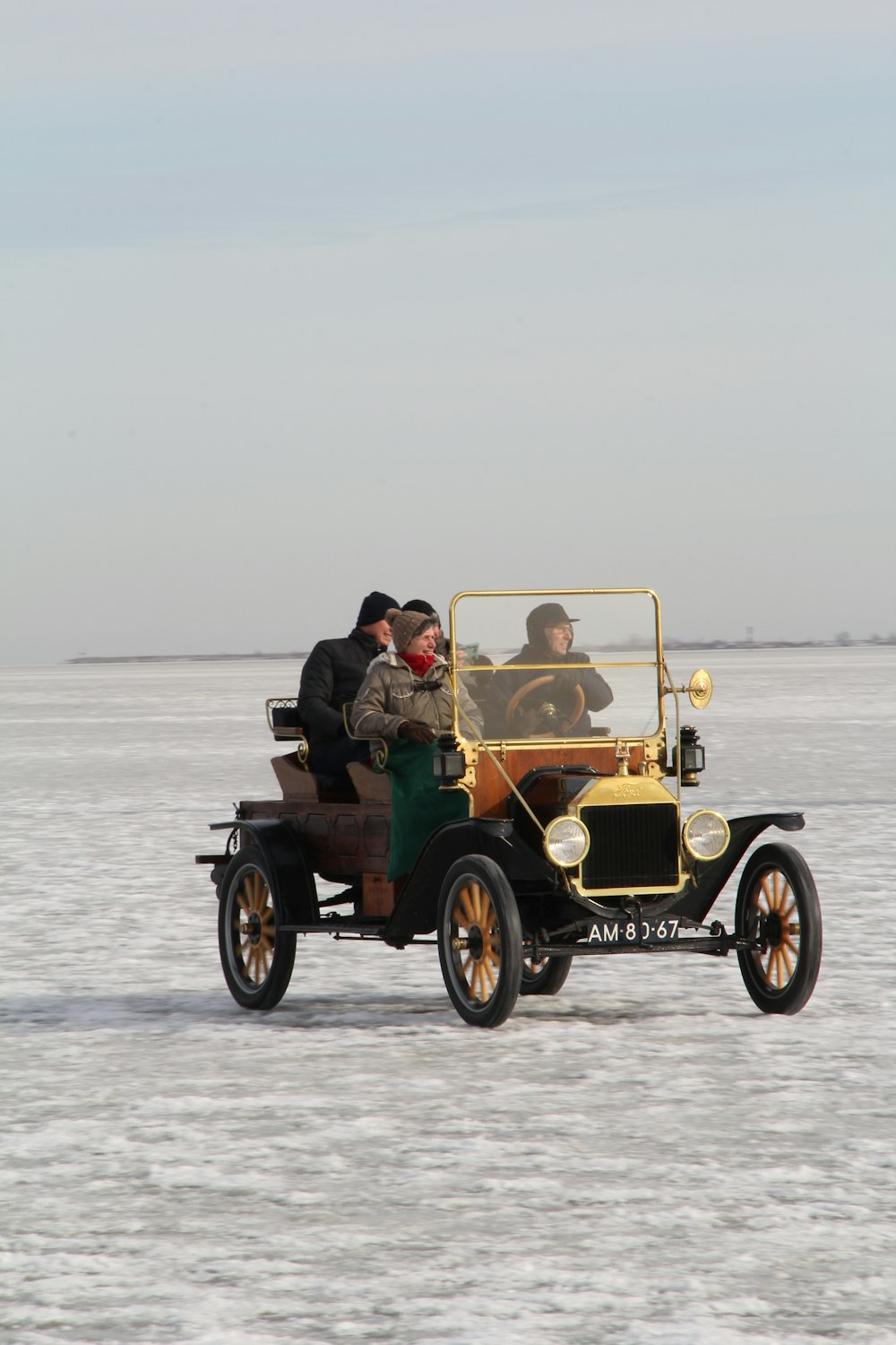 couple riding on green and brown car on sea during daytime