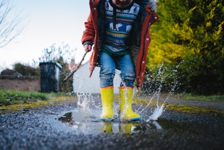 man in red jacket and blue denim jeans running on water