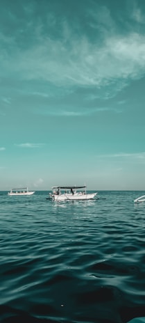 white boat on sea under blue sky during daytime