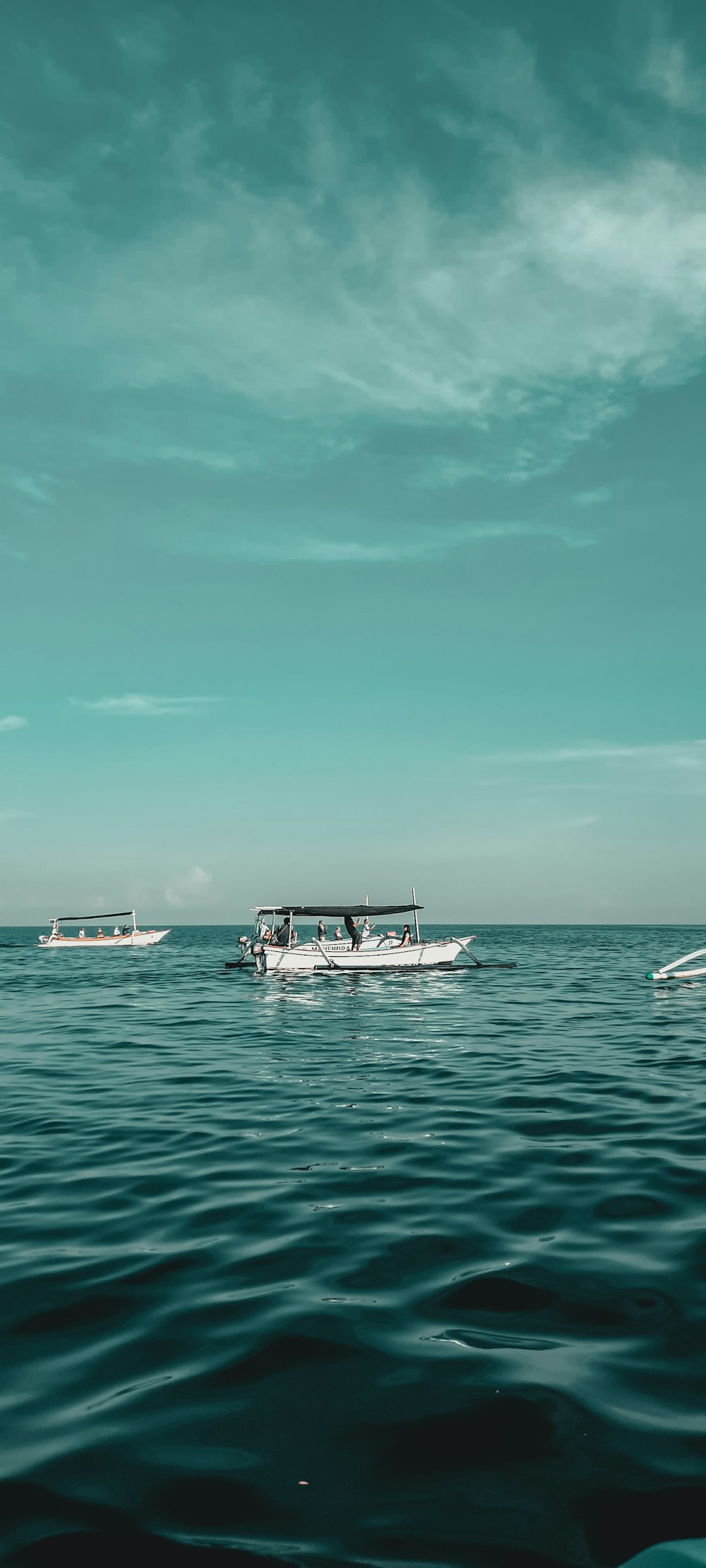 white boat on sea under blue sky during daytime