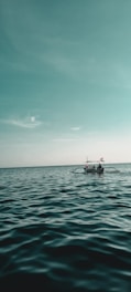 red and white boat on sea under blue sky during daytime
