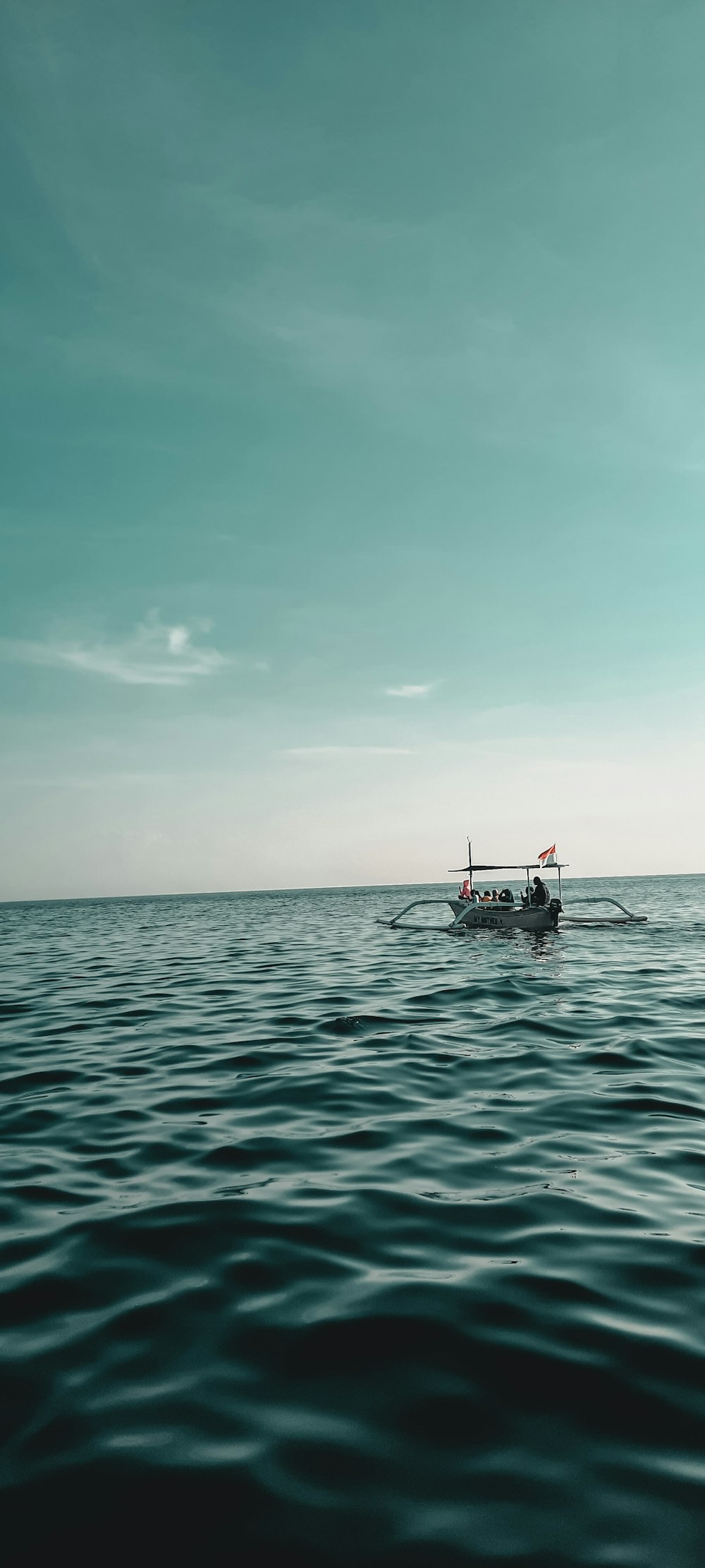 red and white boat on sea under blue sky during daytime