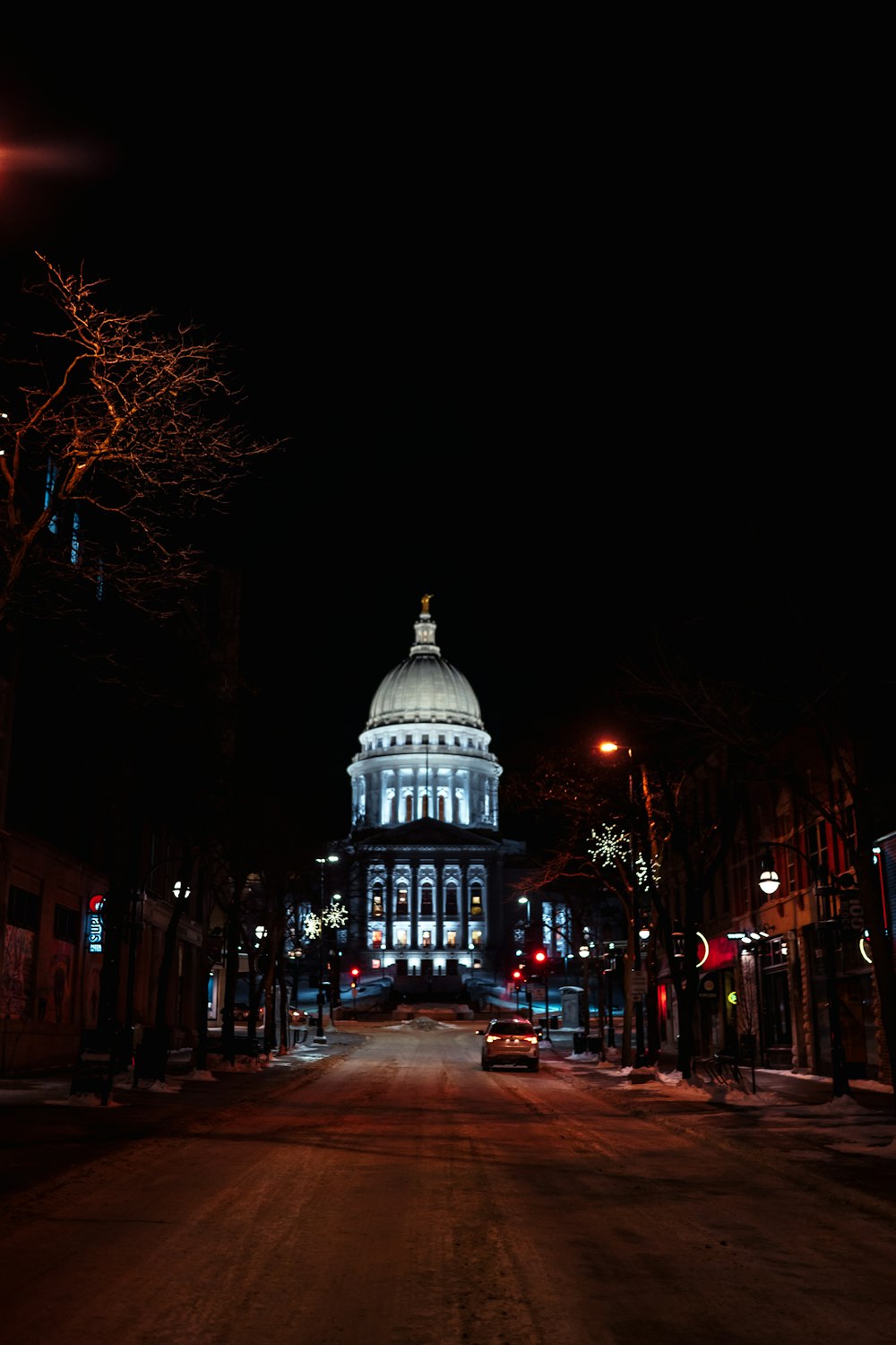 people walking on sidewalk near building during night time