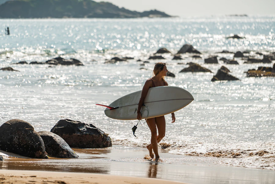 Surfer walking along the shore with a surfboard