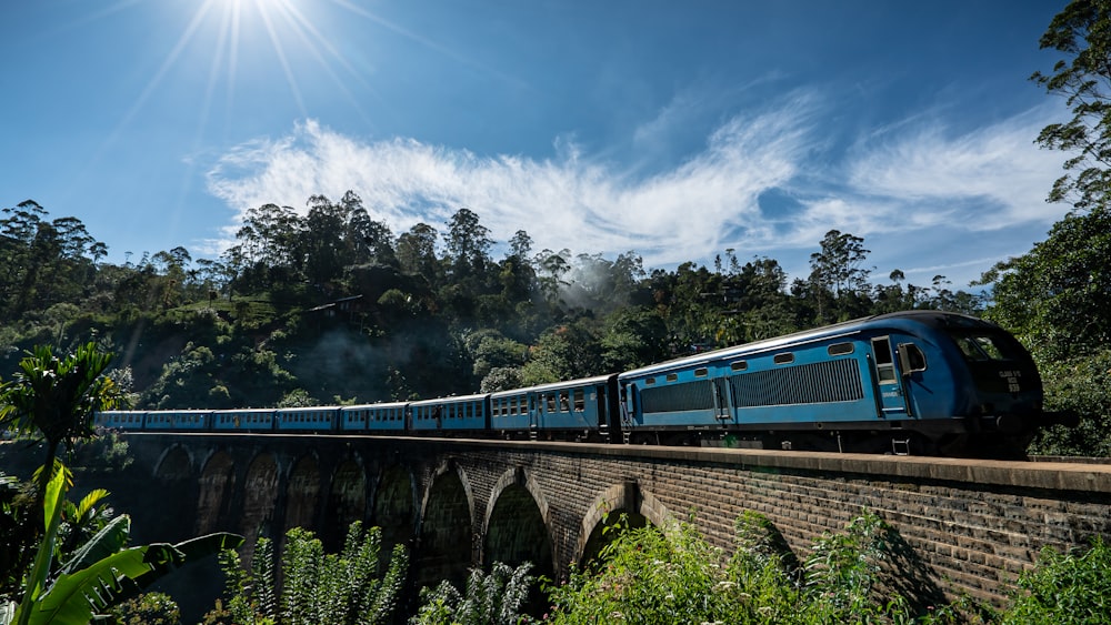 blue train on rail under blue sky during daytime
