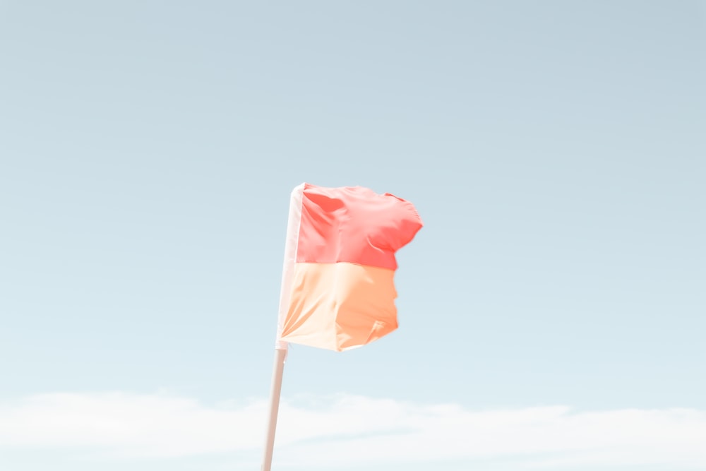 red and white flag on pole during daytime