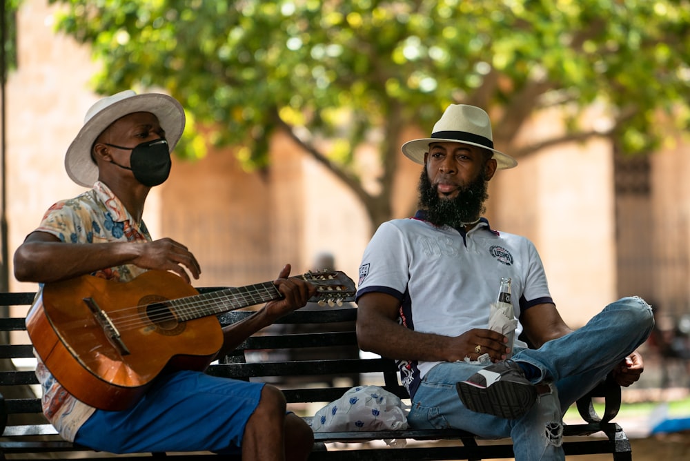 man in white crew neck t-shirt playing acoustic guitar