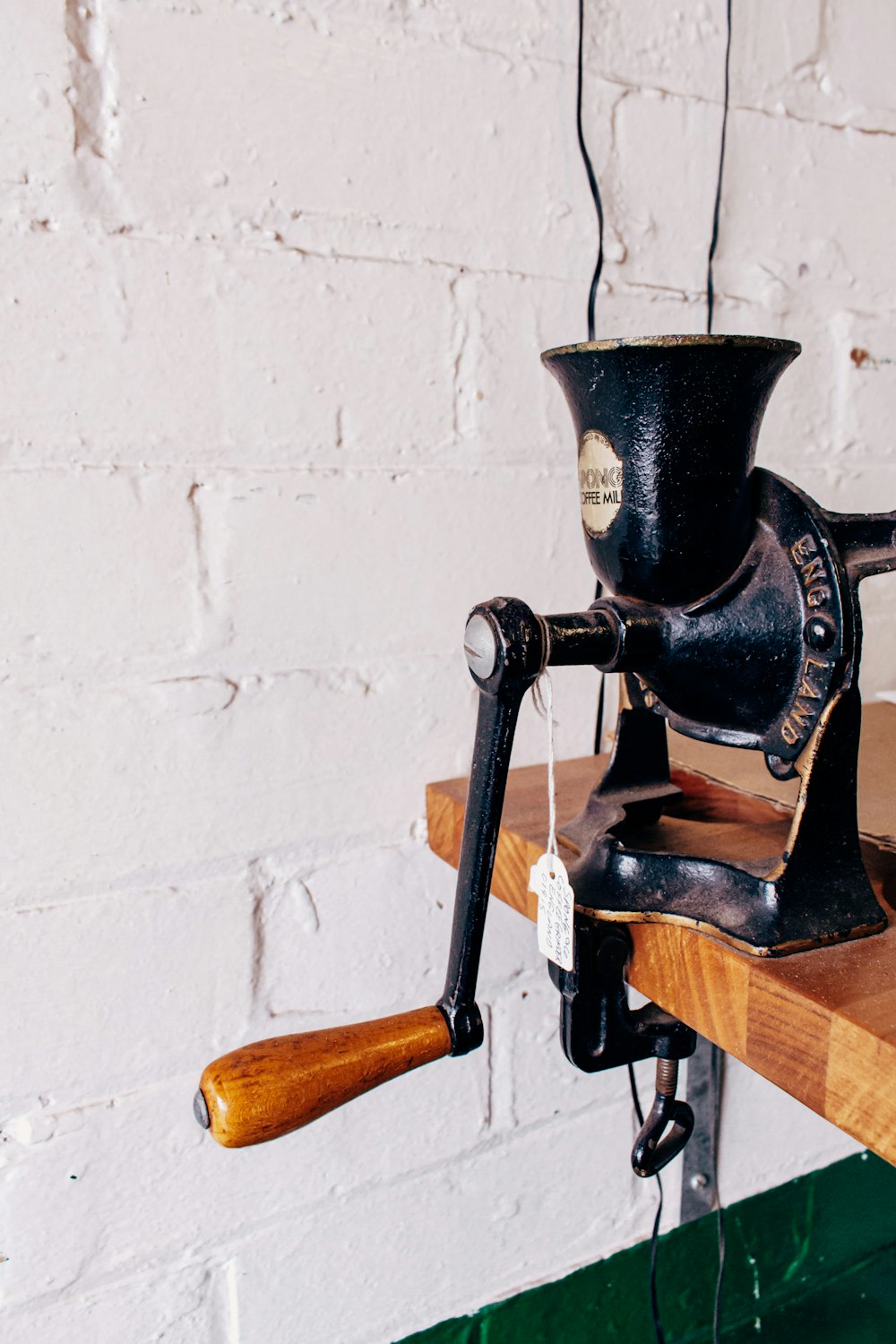 an old fashioned coffee grinder on a wooden shelf