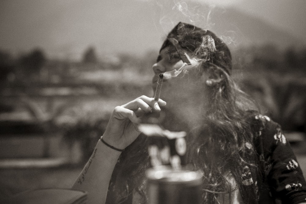 담배를 피우는 여성의 그레이스케일 사진