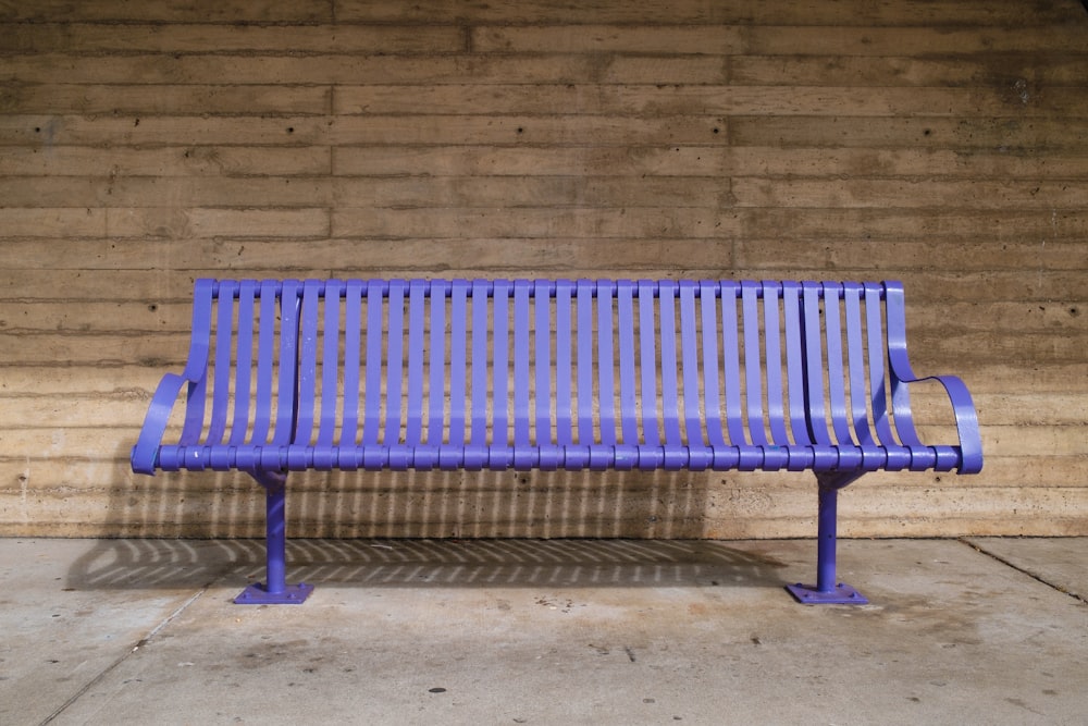 brown wooden bench near gray concrete wall