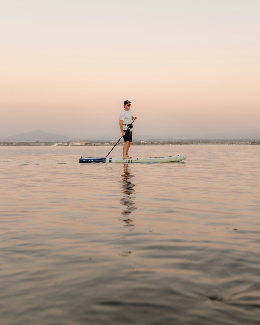 man in blue shirt and black pants riding on surfboard during daytime